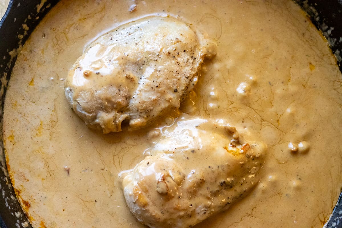chicken breasts are cooked thoroughly in a creamy sauce