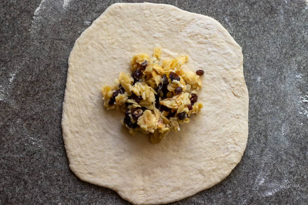 Quarter of the coconut filling is placed in the middle of the dough circle.