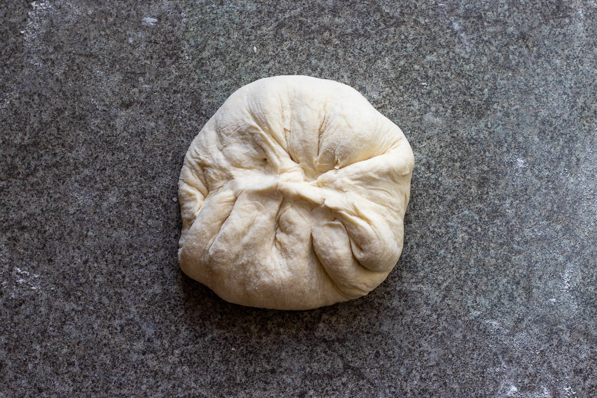 the filled dough circle is reshaped into a ball