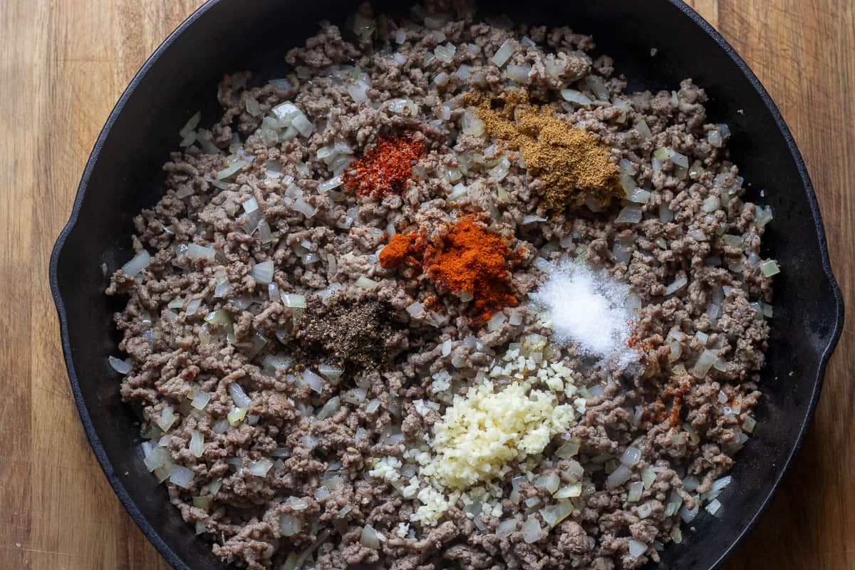 beef and onions are seasoned with salt, pepper, cumin, and chili flakes
