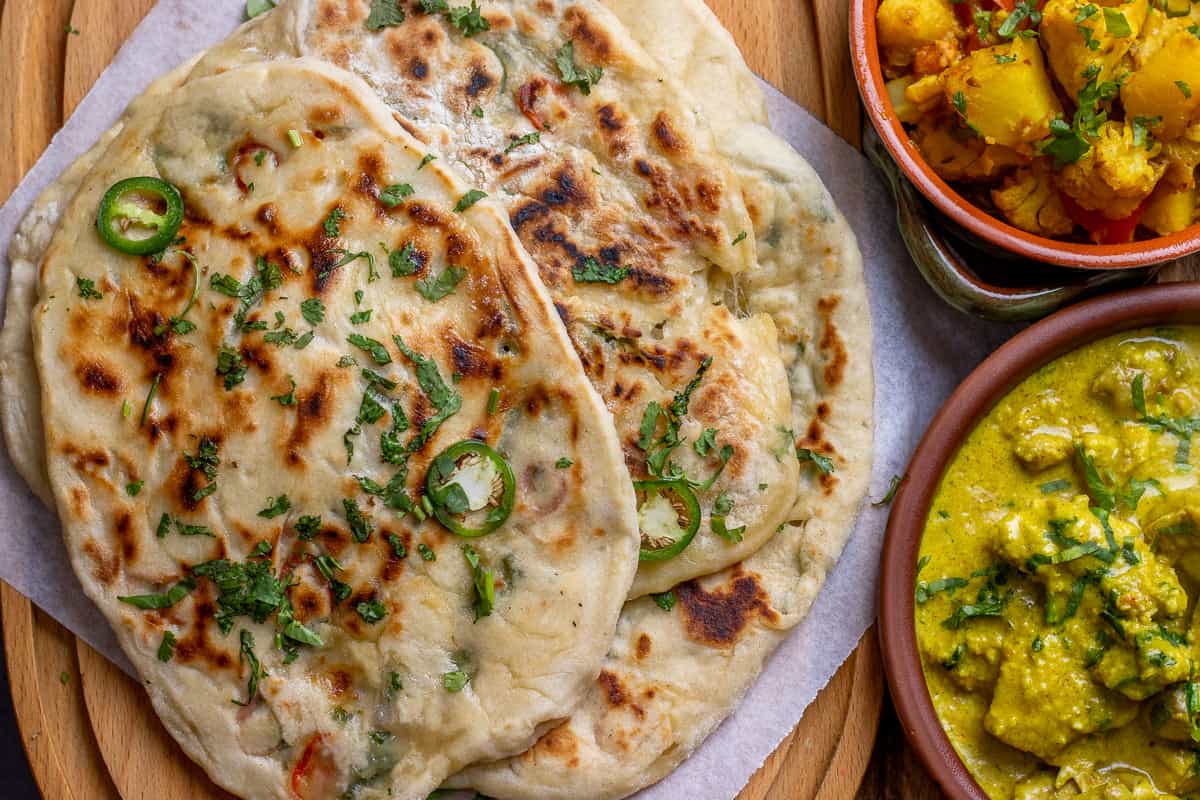 3 pieces of cheesy flatbread served with curries.