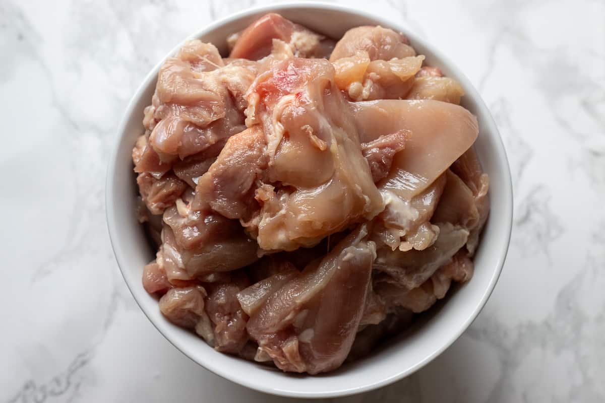 chicken thighs are cut into chunks