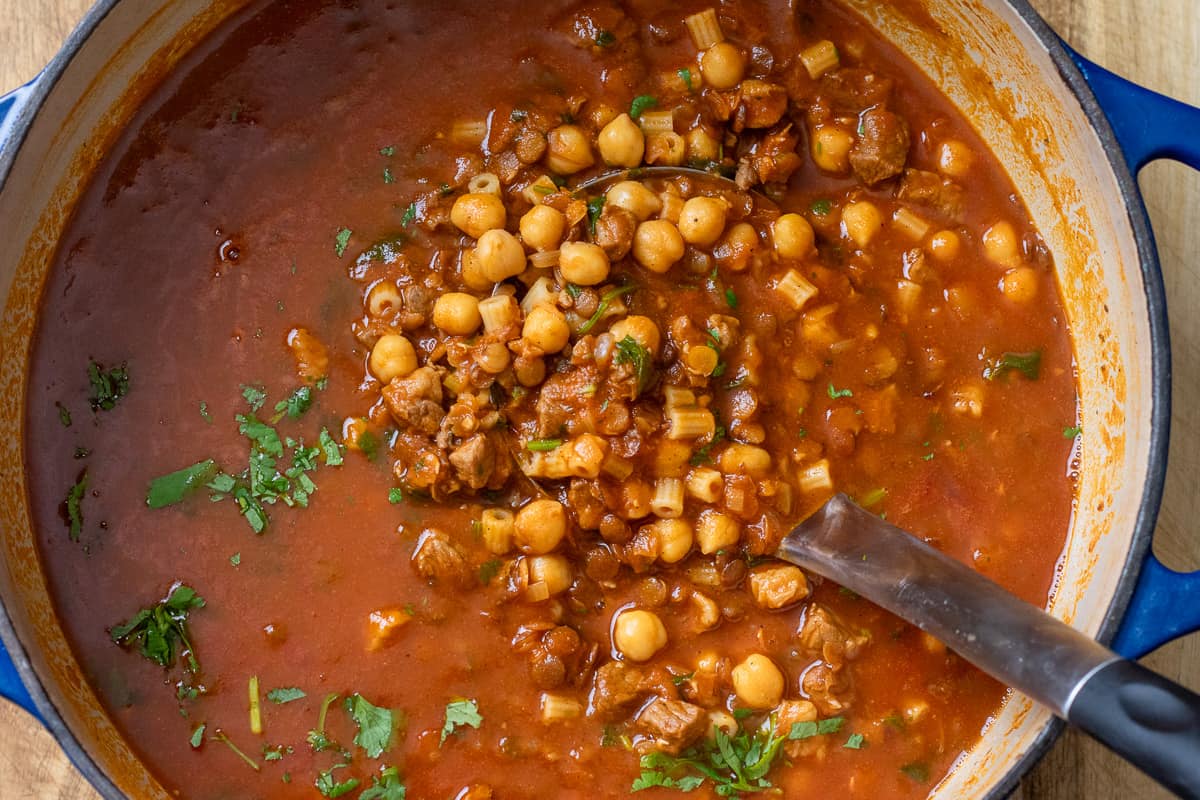 serving Moroccan harira soup with a ladle