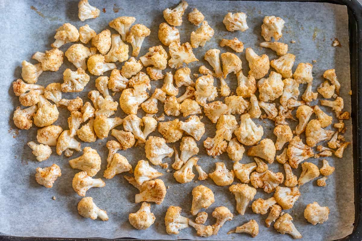 cauliflower florets seasoned and placed on a baking sheet