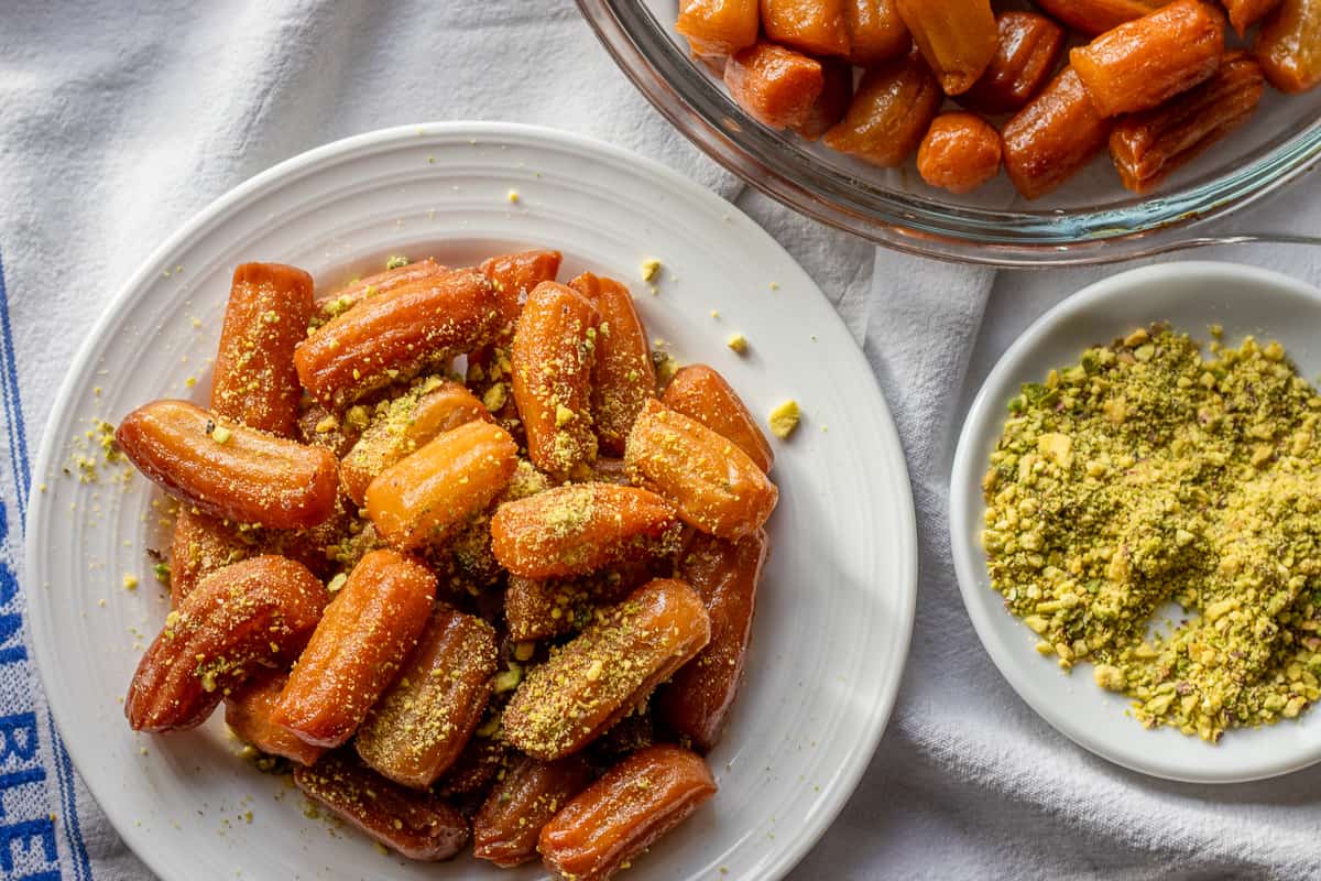 tulumba - turkish fried dough dessert served with extra pistachio on the side