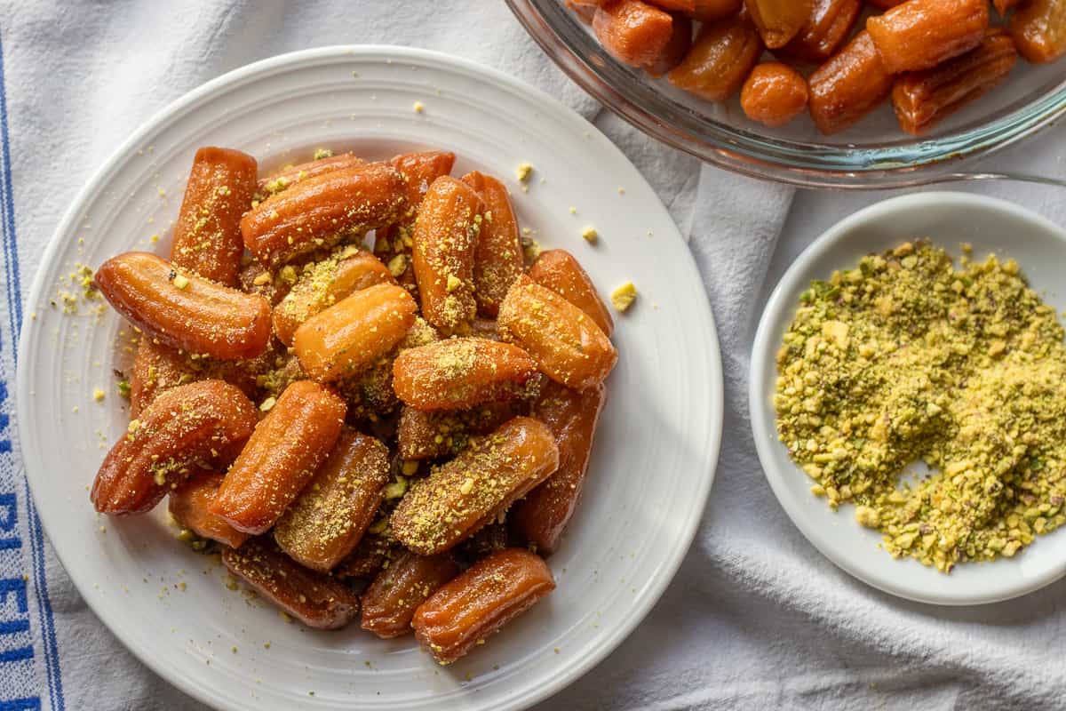 tulumba dessert served with extra ground pistachio on the side