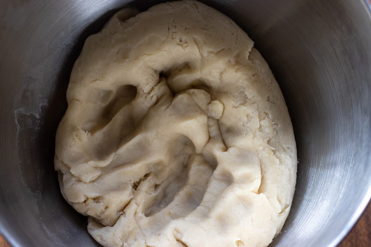 cooled dough is placed in a bowl of a stand mixer