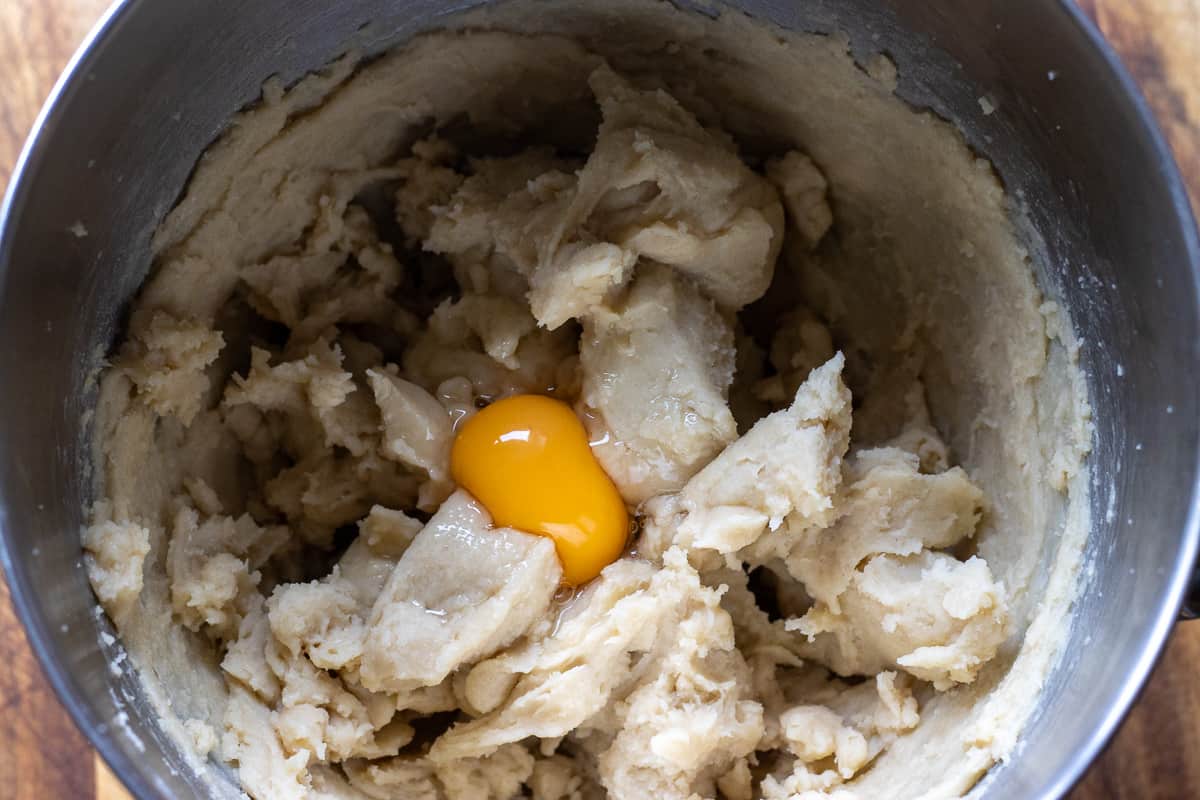 adding eggs one at a time to the dough