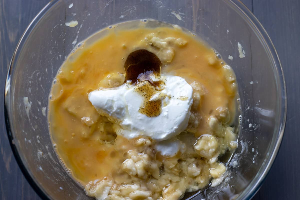 yogurt, egg, vanilla, and sugar are added to mashed bananas