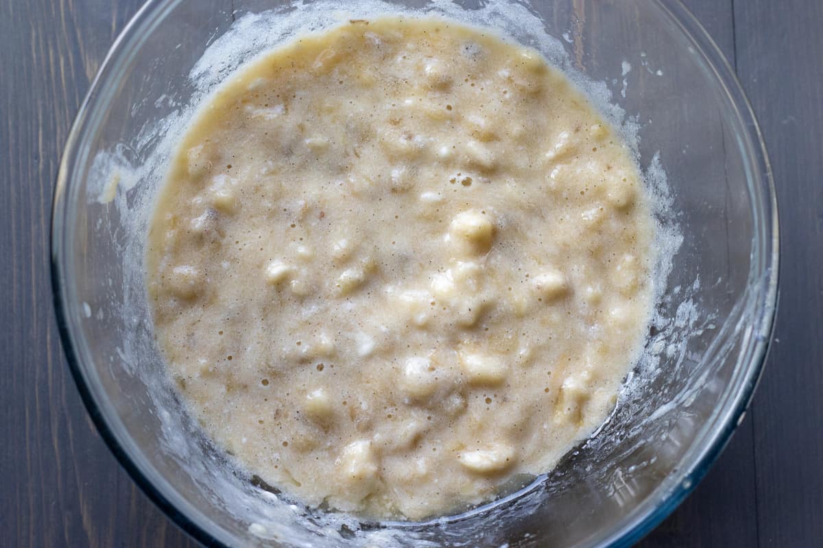 wet ingredients for banana blueberry muffins are mixed in a bowl