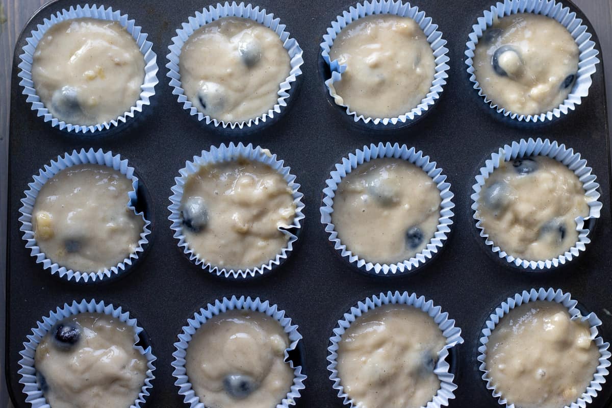 muffin batter is distributed into muffin cases