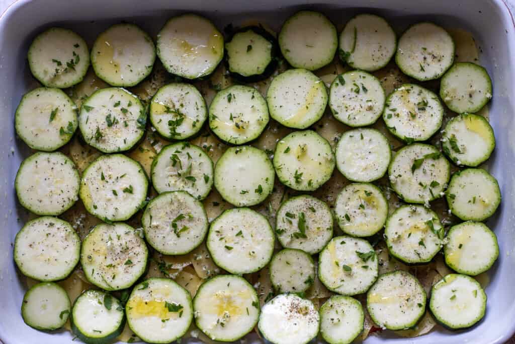 sliced zucchini arranged over potatoes