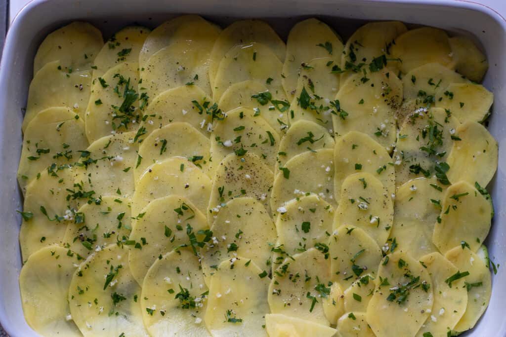 sliced potatoes arranged over sliced zucchini