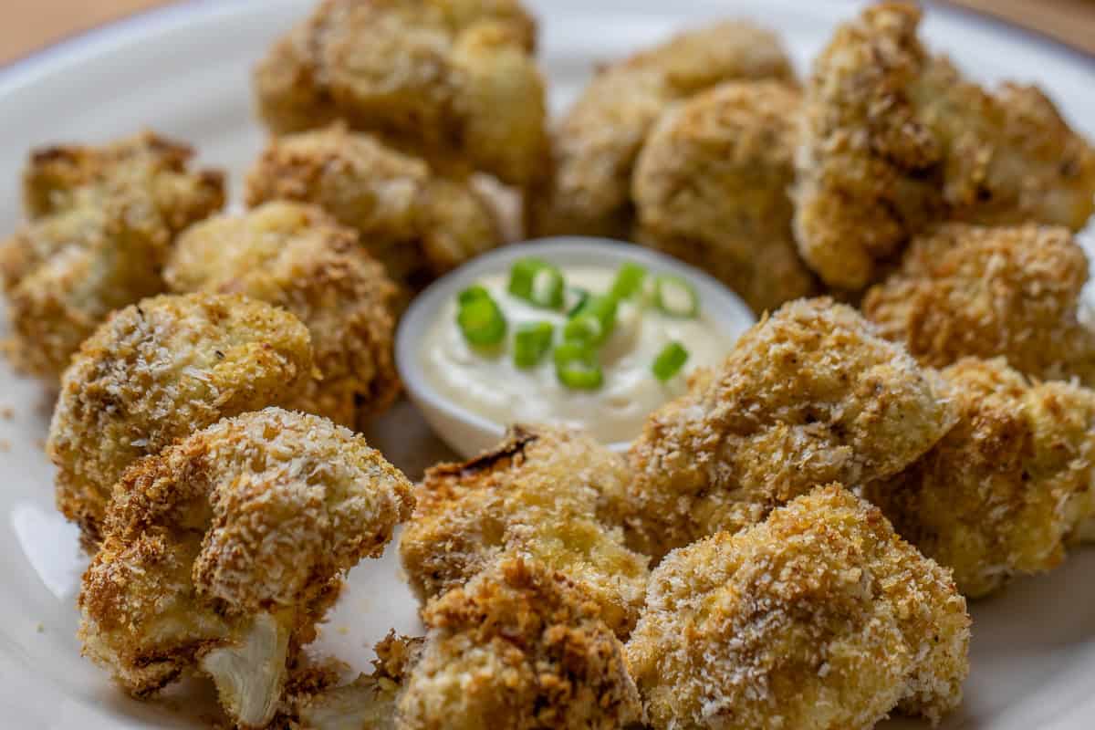 A plate of air fried cauliflower with dipping sauce.