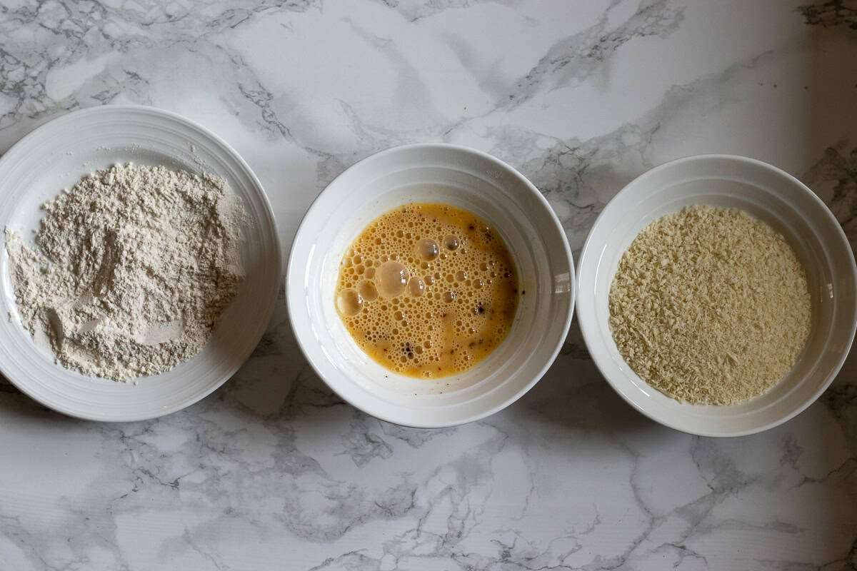 seasoned flour, eggs, and breadcrumbs are placed in bowls