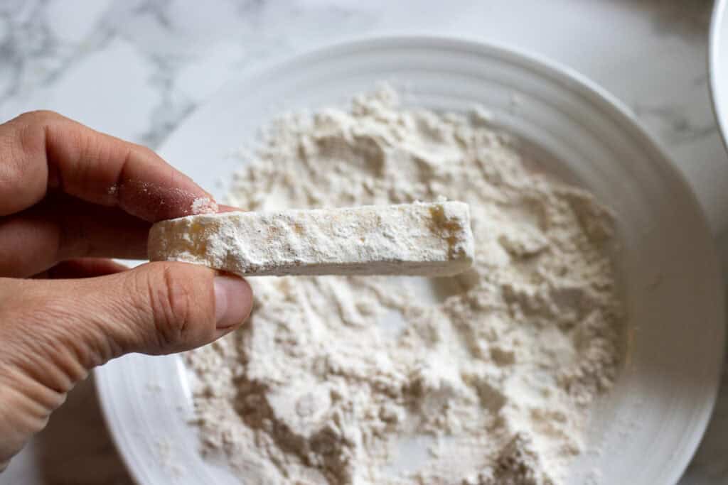 a pice of halloumi is dunked ion beaten egg