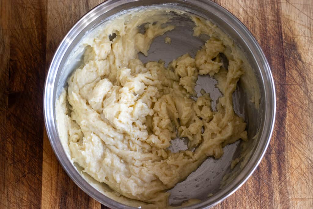 adding the milk gradually to the roux for making béchamel