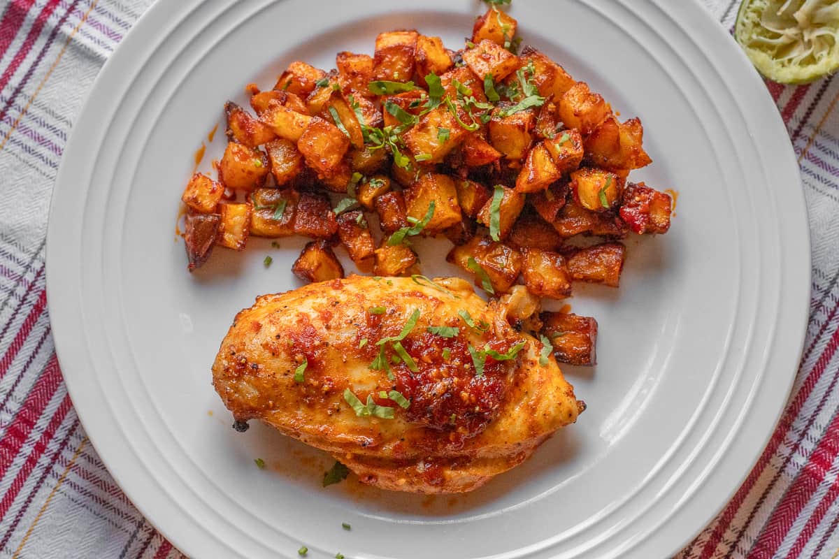 harissa chicken served on a plate with Lebanese potatoes