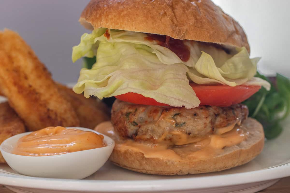 Air fryer chicken patties with lettuce, tomato and cheese on a bun