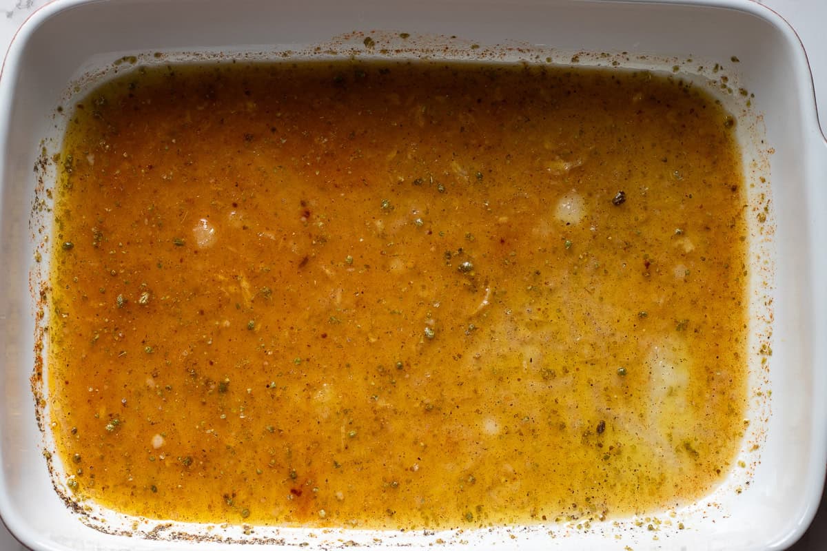 garlic, stock, lemon juice, olive oil, thyme, salt, and pepper are placed in a large baking dish