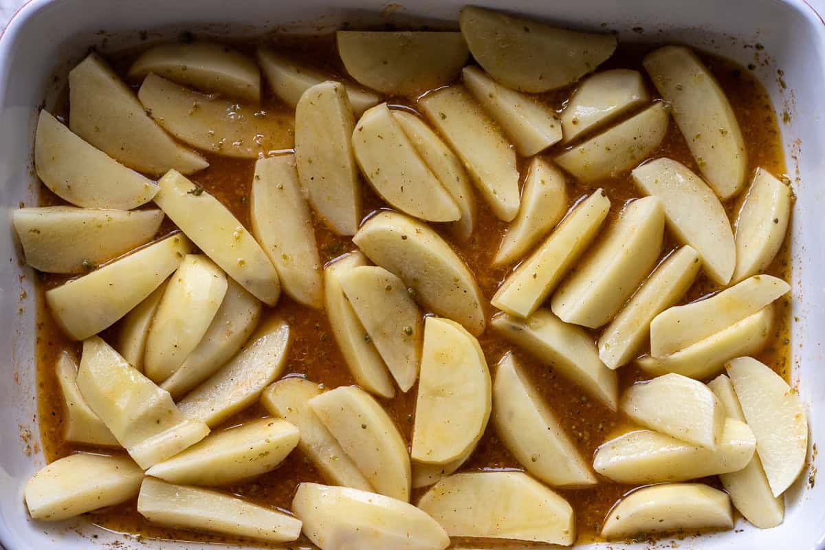 potato wedges are layered in baking dish