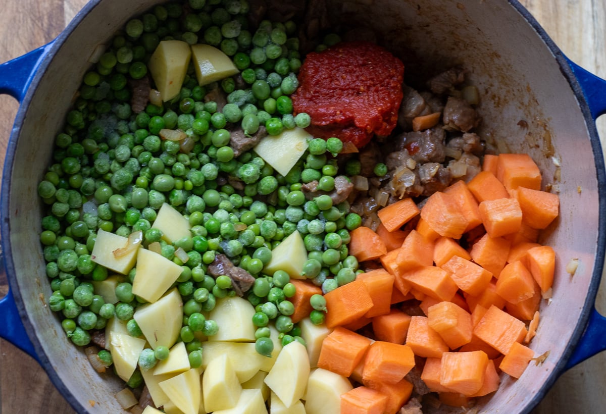 vegetables and tomato paste are added to the pan