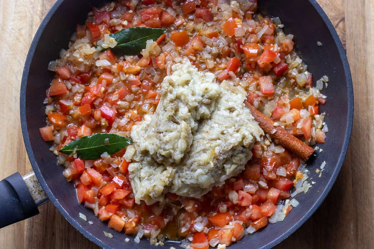 chopped eggplants, bay leaves, and cinnamon stick are added to the pan
