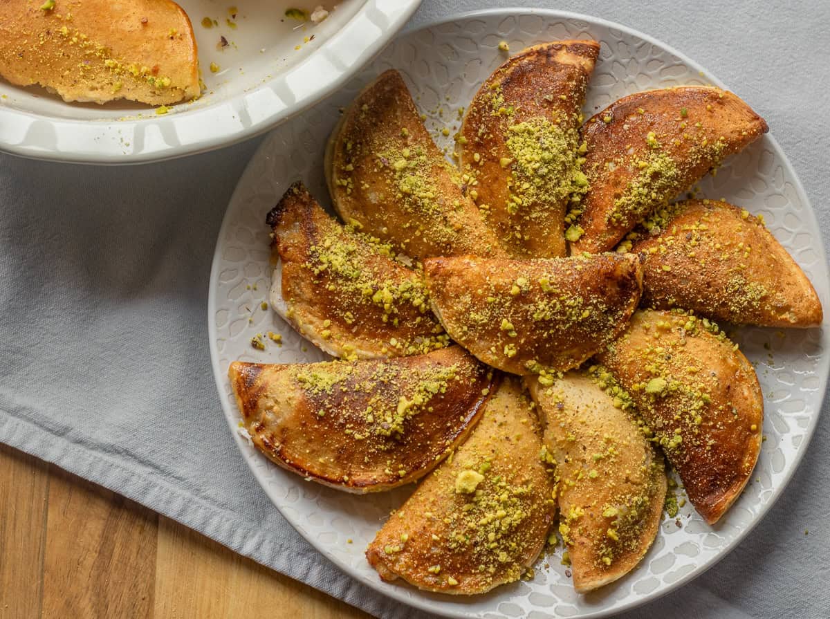 qatayef - missile eastern stuffed pancakes served with ground pistachio and simple syrup