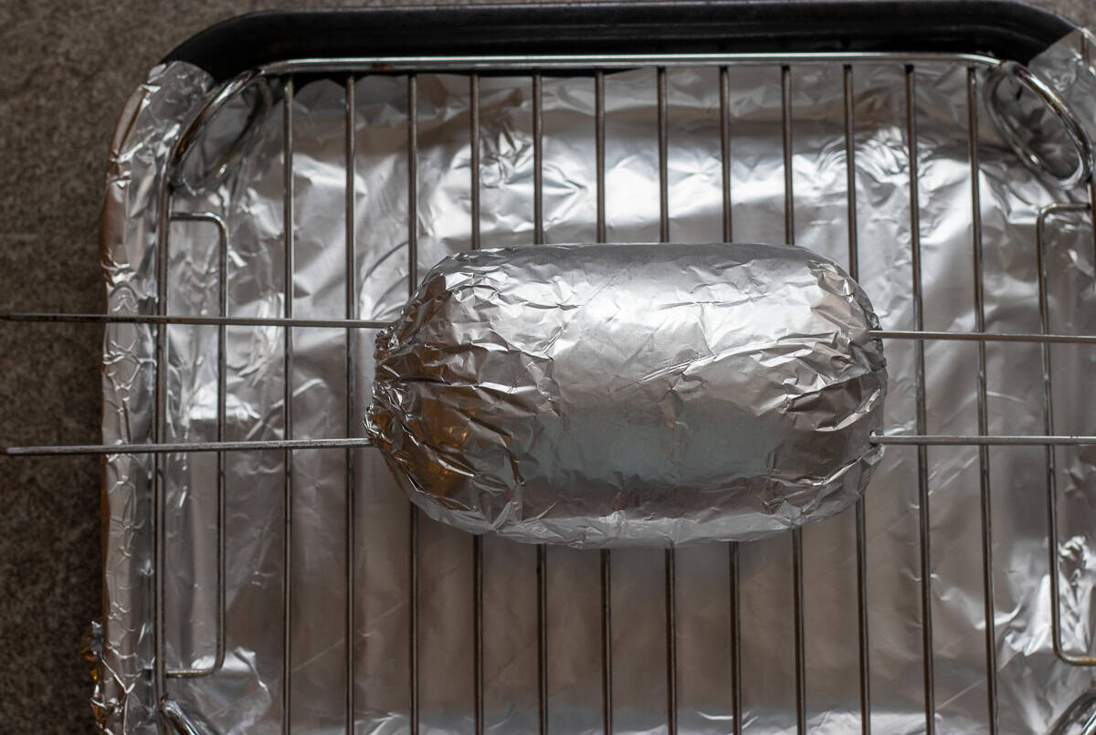 skewers threaded into doner kebab placed on baking tray