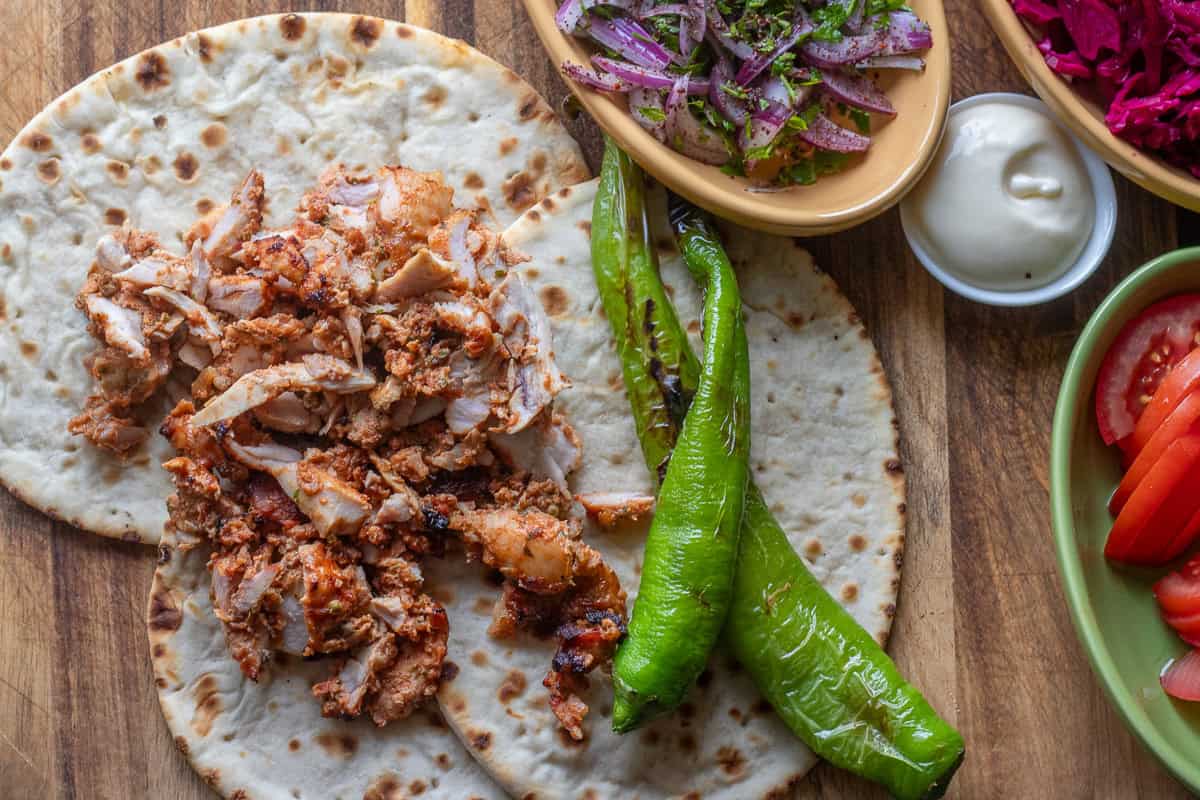 serving chicken Doner Kebab with flatbread and salads