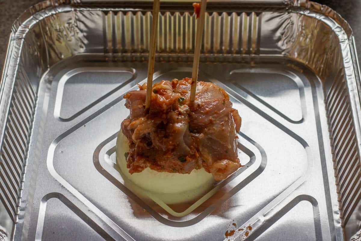 threading chicken thighs into skewers