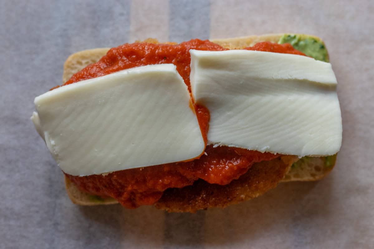2 slices of mozzarella are placed on top of tomato sauce
