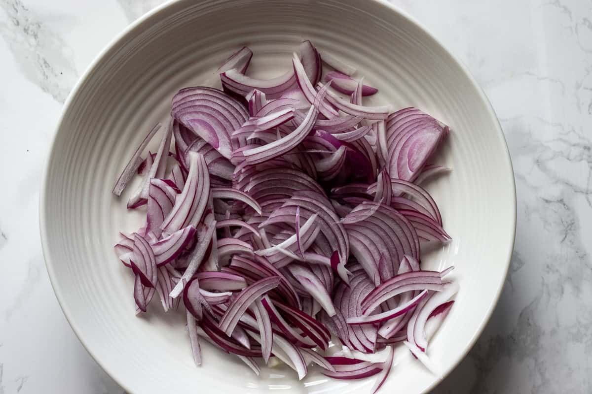 thinly sliced onions are placed in a bowl
