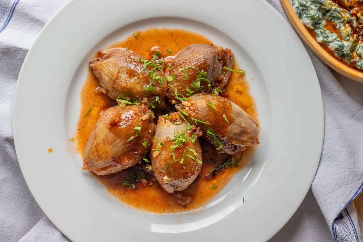 5 pieces of cooked sogan Dolmasi served with its cooking liquid