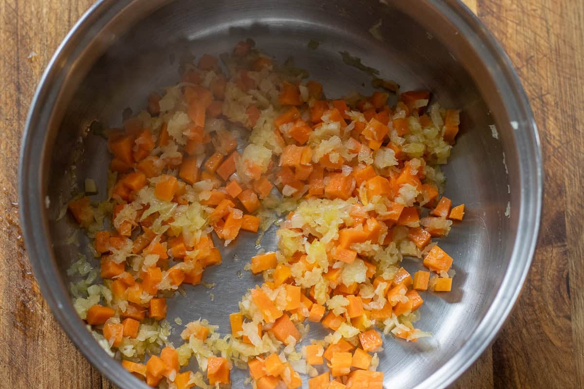 preparing the fava base by sautéing onions, garlic, and carrots