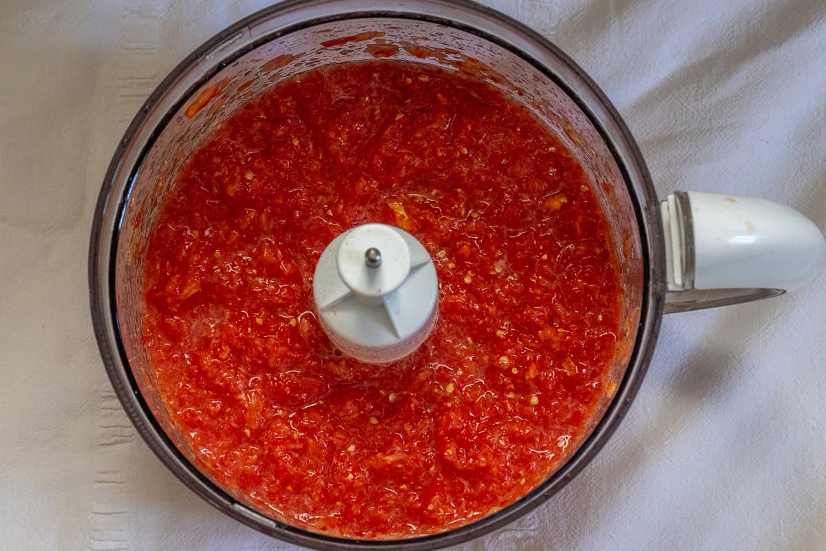 tomatoes are blended in a food processor for making homemade Turkish tarhana