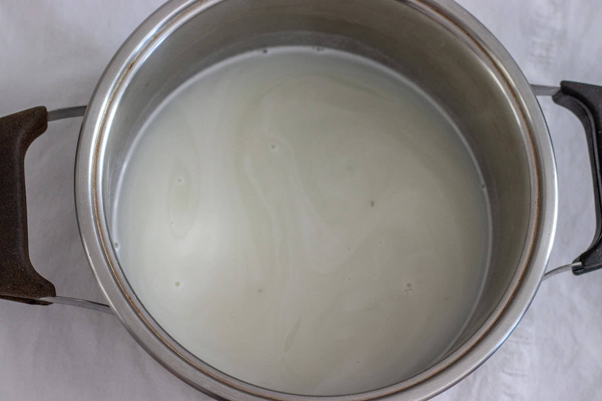 milk and sugar are combined in a pot to make syrup for halva