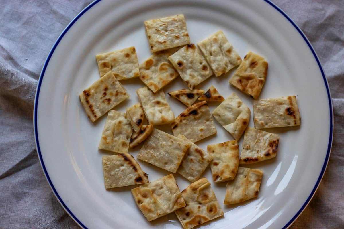 lightly toasted pita bread pieces are arranged on a plate