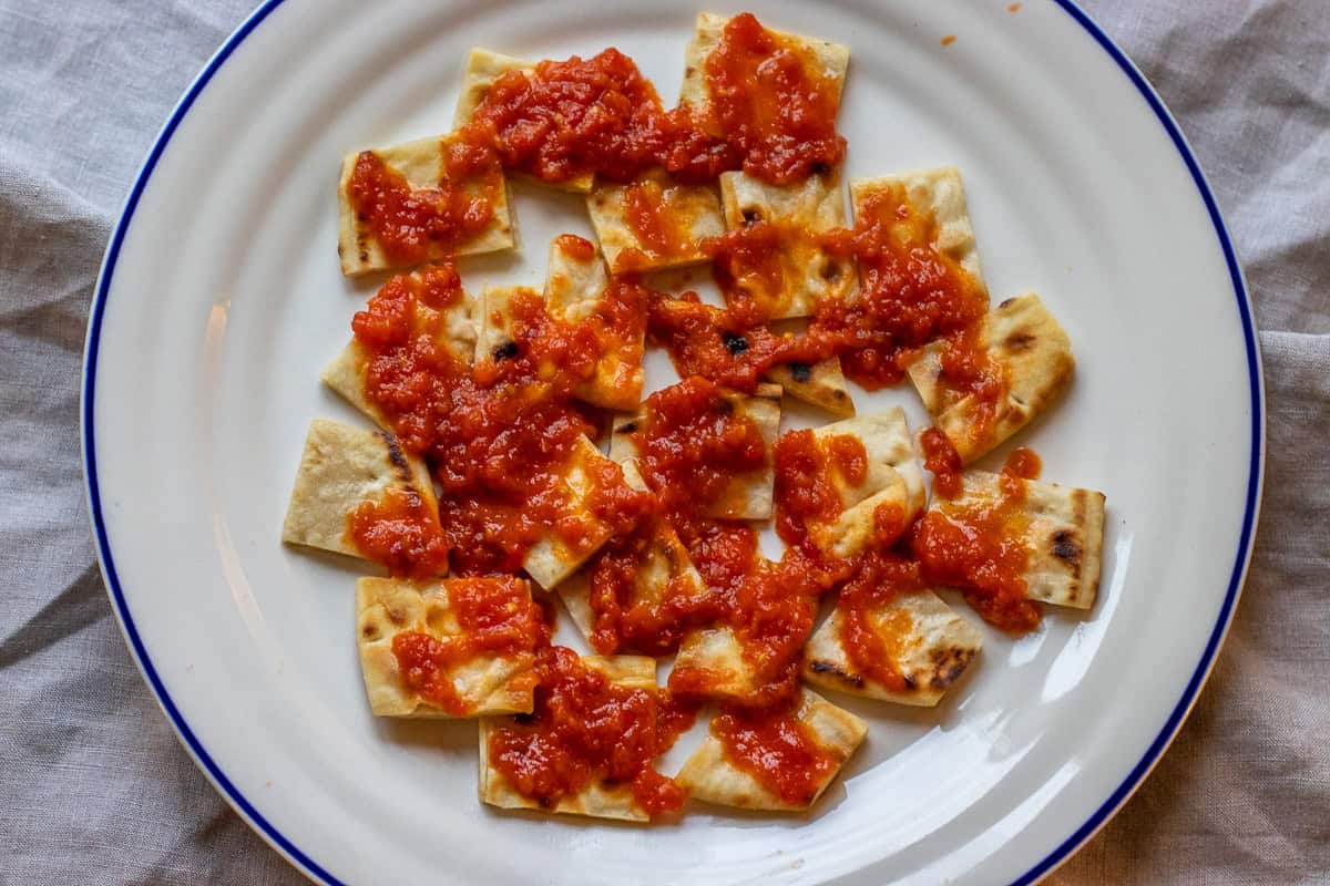pita bread is soaked with tomato sauce
