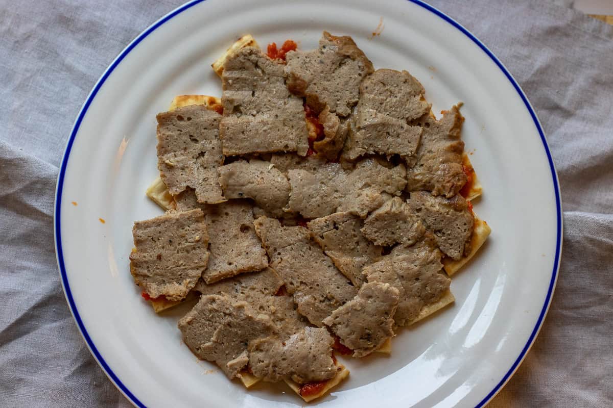 sliced doner meat is placed on top of pita bread