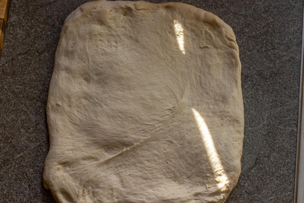 Bread dough is shaped into a rectangle.