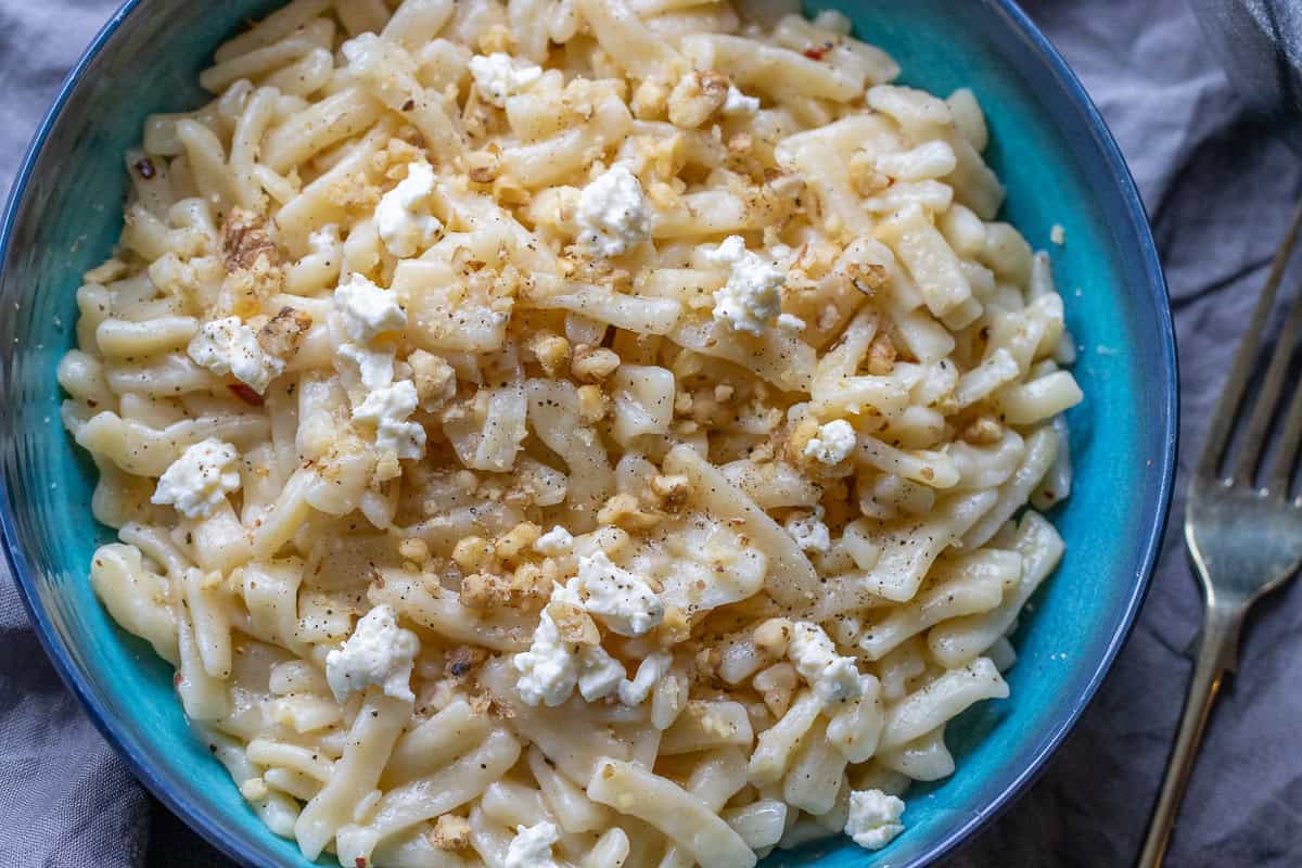 crushed walnuts and crumbled feta cheese are sprinkled on top of cooked eriste