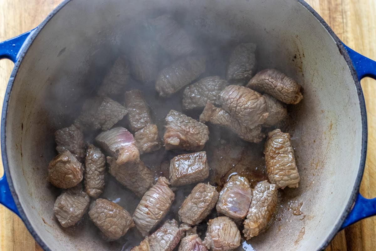 searing the beef with olive oil in a dutch oven