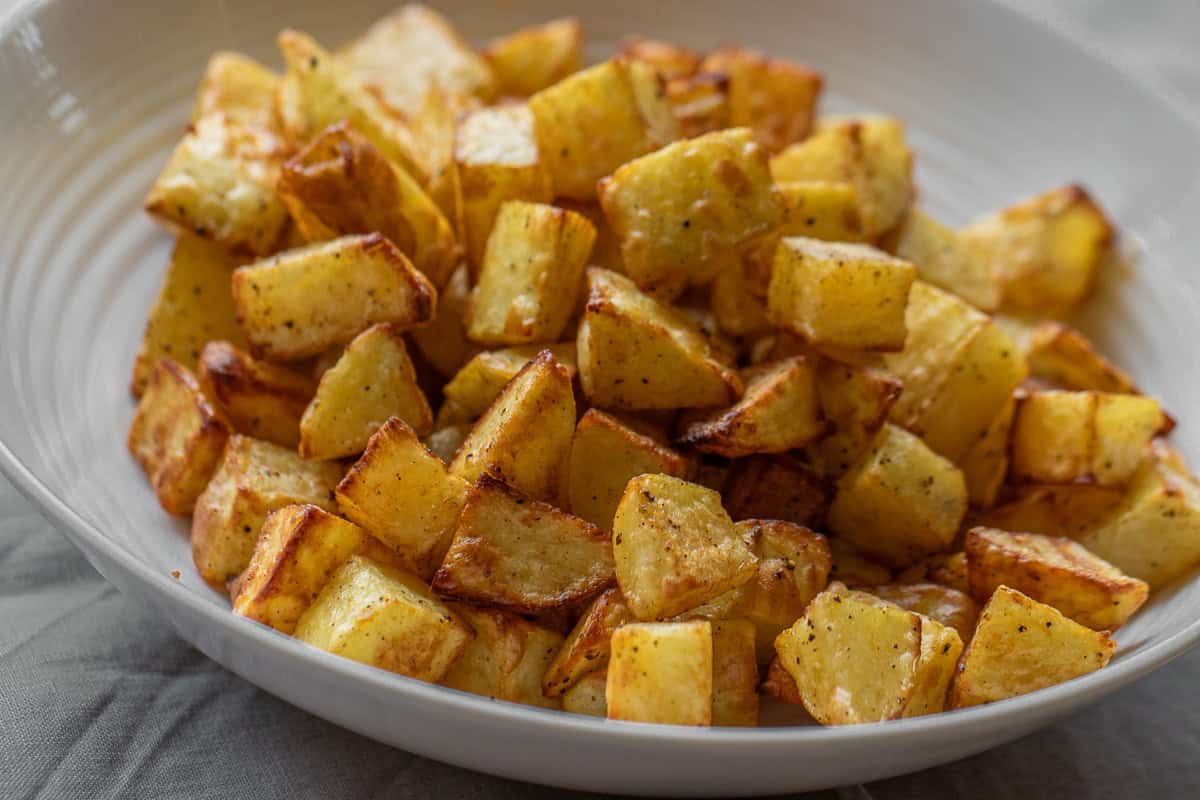 A white bowl filled with cooked potatoes
