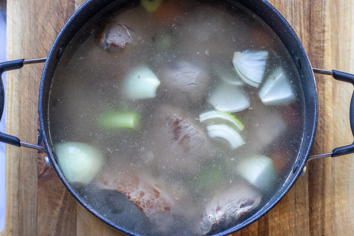 vegetables, aromatics, and water are added to the pan