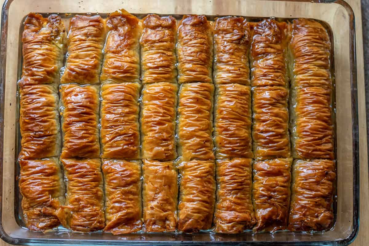 baked baklava rolls are soaked with cooled syrup