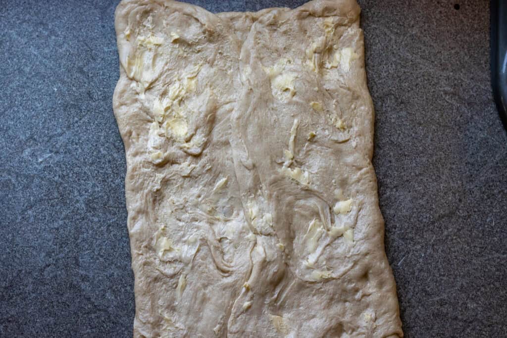 softened butter is spread over the dough second time