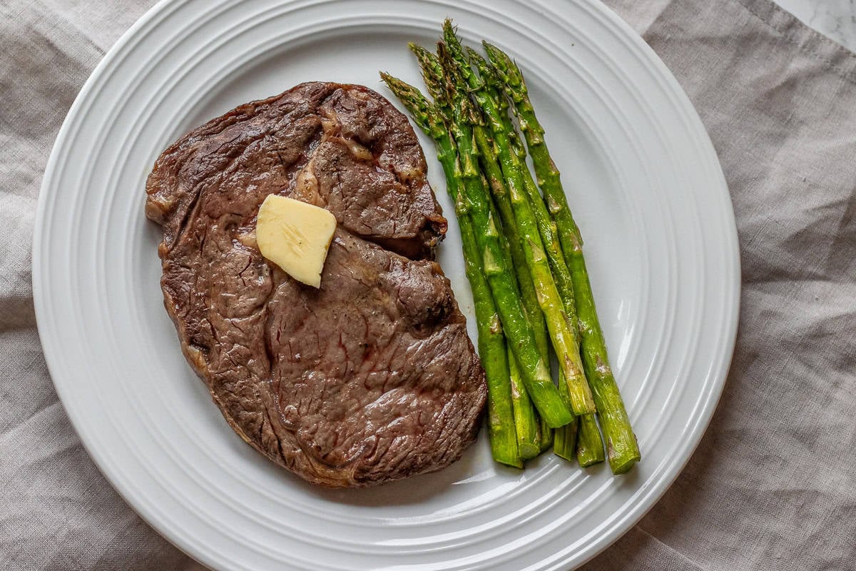A steak and asparagus on a plate.