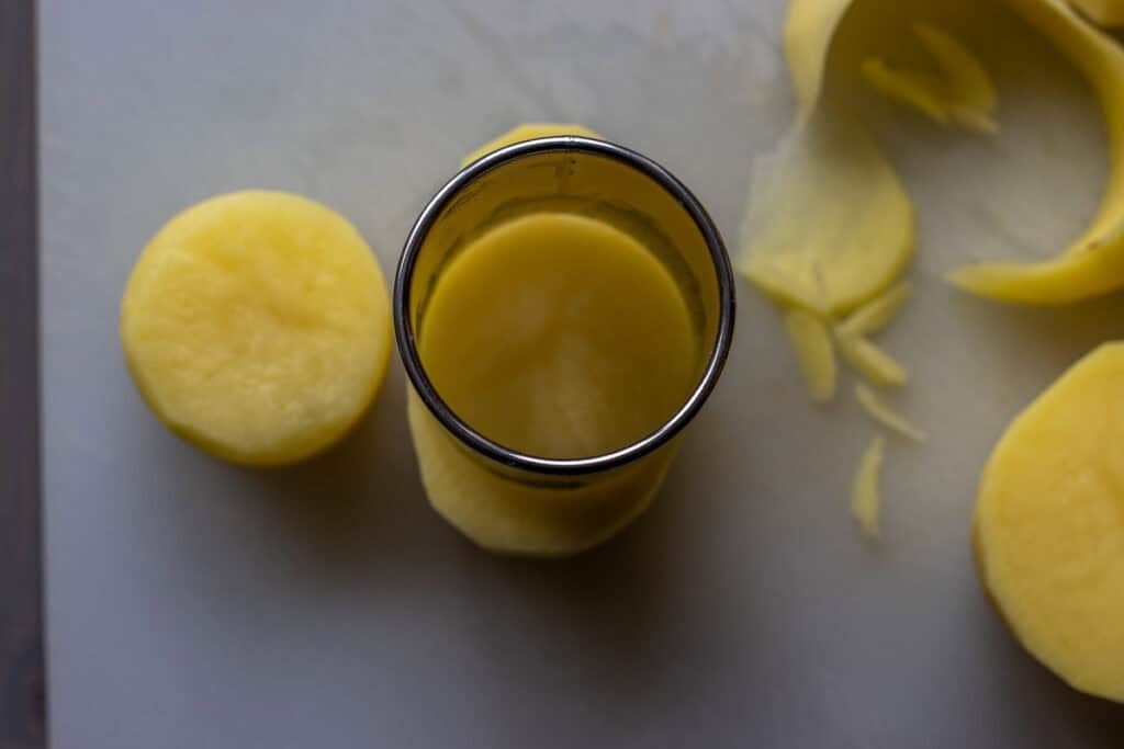 cutting a potato using a ring cutter for fondant potatoes