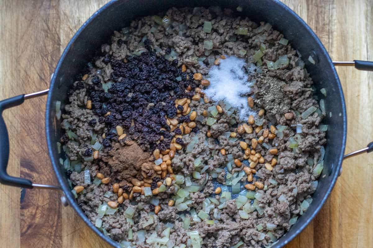 spices and currants are added to the pot